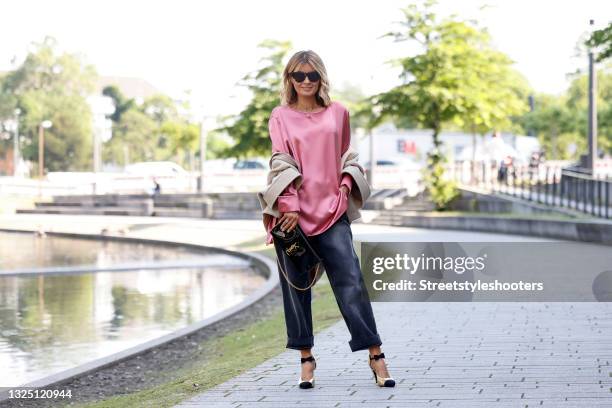Influencer Gitta Banko wearing a beige short oversized cape-coat by Chloe, a pink silk top by max Mara, grey-blue denim jeans pants by Balenciaga, a...
