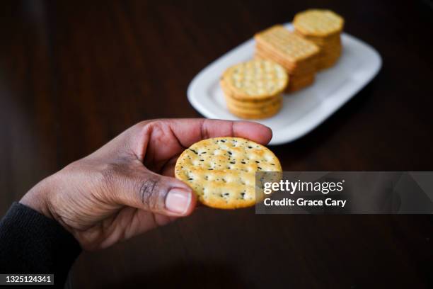 woman snacks on crackers - crackers stock pictures, royalty-free photos & images