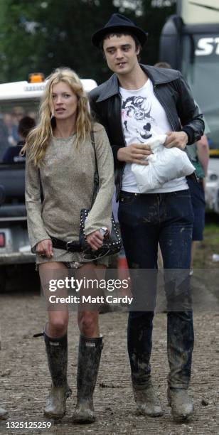 Model Kate Moss and singer Pete Doherty walk backstage during the 2005 Glastonbury Festival being held at Worthy Farm in Pilton, near Glastonbury on...