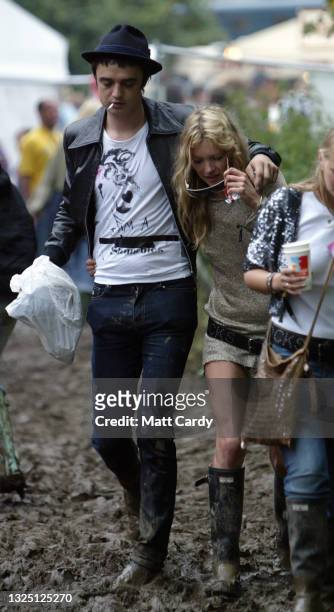 Model Kate Moss and singer Pete Doherty walk backstage during the 2005 Glastonbury Festival being held at Worthy Farm in Pilton, near Glastonbury on...