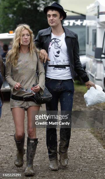 Model Kate Moss and singer Pete Doherty walk backstage during the 2005 Glastonbury Festival being held at Worthy Farm in Pilton, near Glastonbury on...