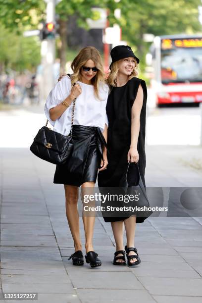 Fashion designer Sue Giers wearing a white blouse by SoSUE, a black vegan leather mini skirt by SoSUE, a black bag with gold details by Chanel, black...