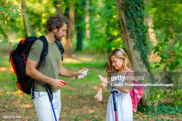 o homem e sua filha estão coçando a pele coceira devido ao ataque de insetos na natureza. - insect bites images - fotografias e filmes do acervo