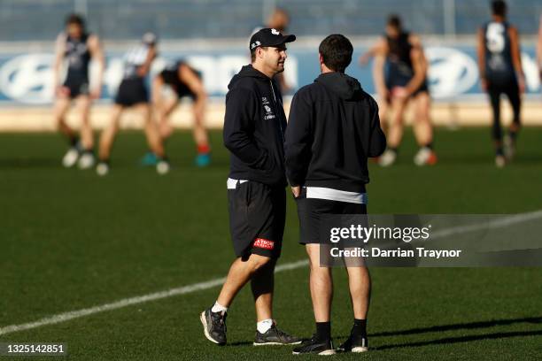 David Teague, senior coach of Carlton speaks with assistant Brent Stanton during a Carlton Blues AFL training session at Ikon Park on June 24, 2021...