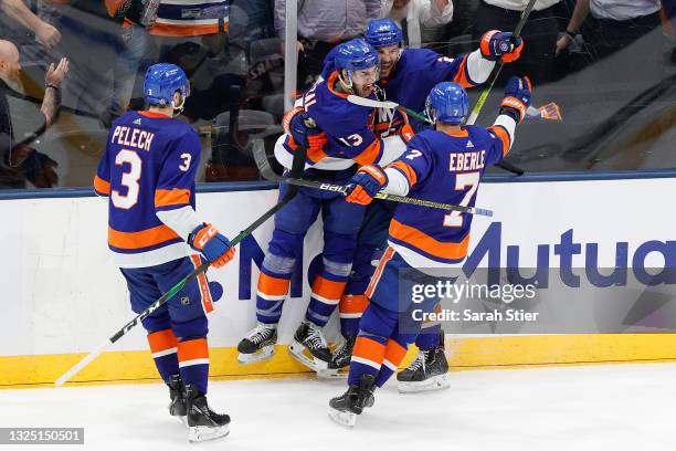 Scott Mayfield of the New York Islanders is congratulated by his teammates after scoring a goal against the Tampa Bay Lightning during the third...