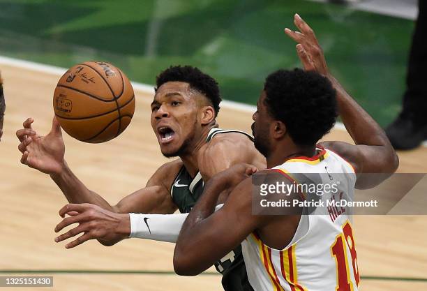 Giannis Antetokounmpo of the Milwaukee Bucks is pressured by Solomon Hill of the Atlanta Hawks during the fourth quarter in game one of the Eastern...