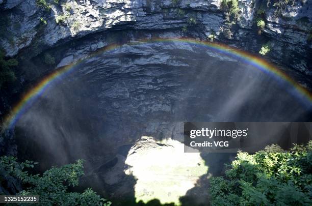 Rainbow is seen at a 290-meter deep karst sinkhole, located near the village of Luoquanyan, on June 23, 2021 in Xuan en County, Enshi Tujia and Miao...