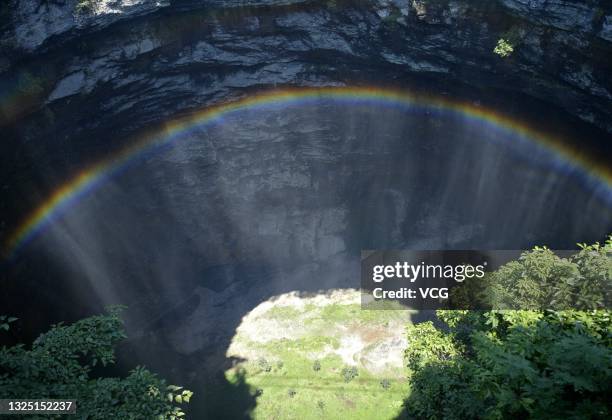 Rainbow is seen at a 290-meter deep karst sinkhole, located near the village of Luoquanyan, on June 23, 2021 in Xuan en County, Enshi Tujia and Miao...