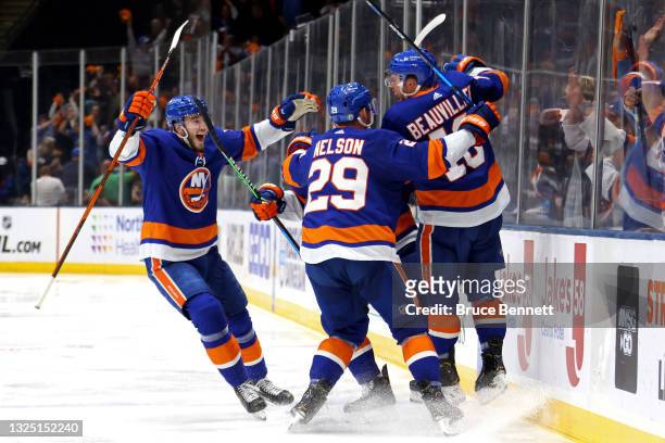 Anthony Beauvillier of the New York Islanders is congratulated by Brock Nelson and Noah Dobson after scoring the game-winning goal during the first...