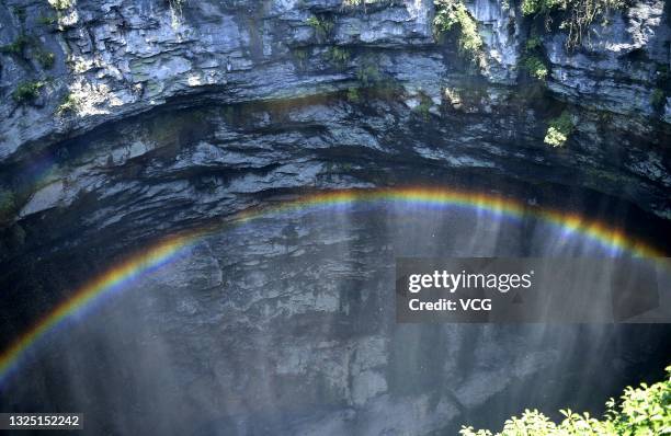 Rainbow is seen at a 290-meter deep karst sinkhole, located near the village of Luoquanyan, on June 23, 2021 in Xuan en County, Enshi Tujia and Miao...