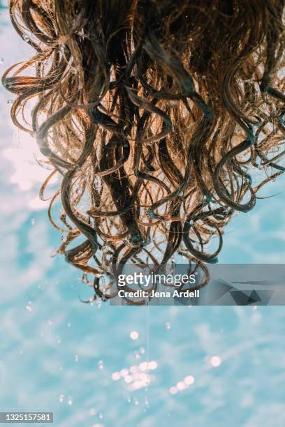 summer hair care: wet hair, curly hair dripping water in swimming pool - curly hair - fotografias e filmes do acervo