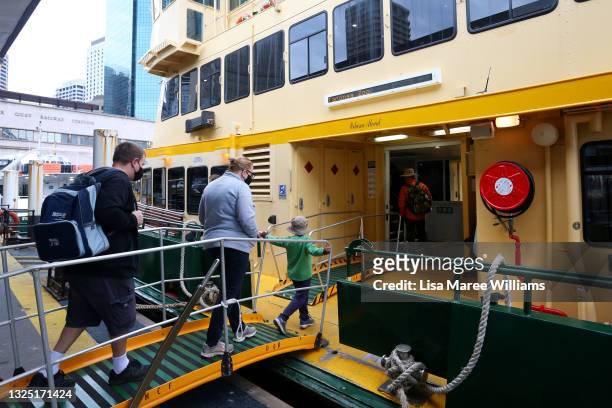 Young family board a ferry at Circular Quay on June 24, 2021 in Sydney, Australia. A steady increase in Covid-19 cases in Sydney prompted the...