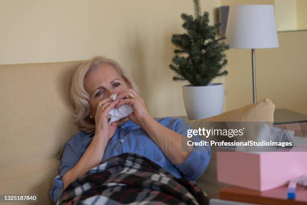 sick older woman in the bed with seasonal allergy and temperature. - one senior woman only stock pictures, royalty-free photos & images