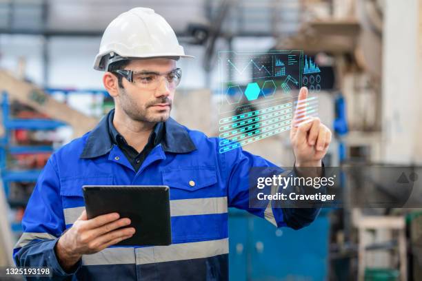 a portrait of a confident engineer  touch the button at the screen and use digital tablet in a heavy industrial factory, concepts engineer working in the factory. - tracking progress stock pictures, royalty-free photos & images