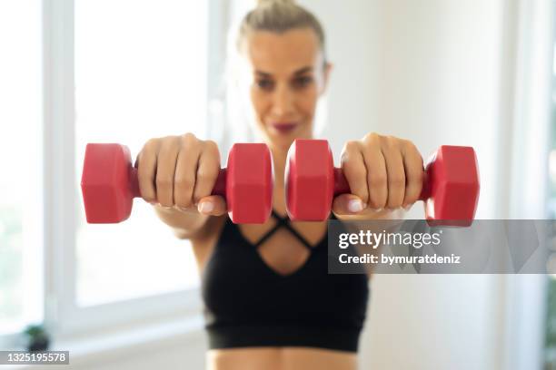 woman practicing doing fitness at home - womens hand weights stock pictures, royalty-free photos & images