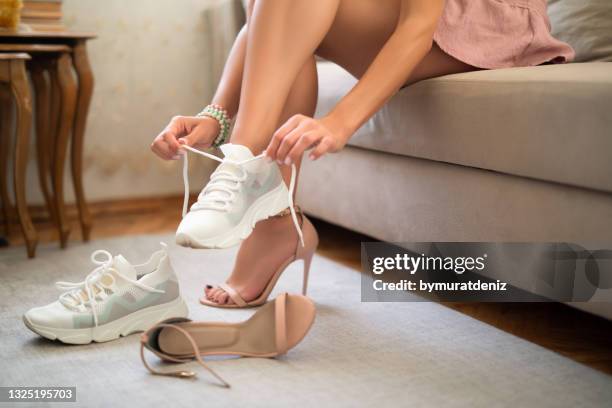 mulher trocando de sapatos - tênis calçados esportivos - fotografias e filmes do acervo