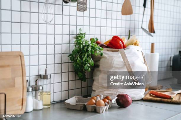 un sac réutilisable rempli de légumes biologiques colorés et frais et d’épicerie sur le comptoir de la cuisine. achats zéro déchet et concept de mode de vie durable - cuisine du monde photos et images de collection