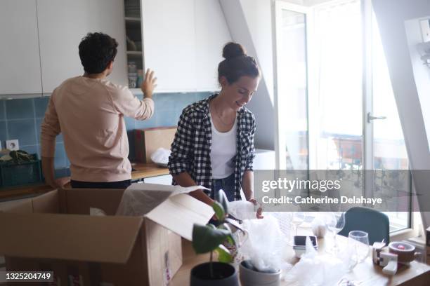 moving of a young couple - desempaquetar fotografías e imágenes de stock