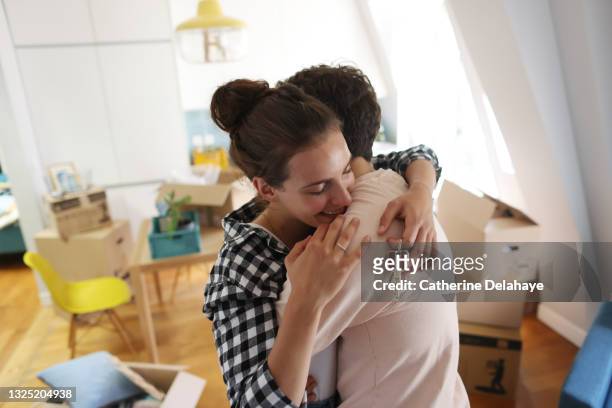 a happy young couple move into a new apartment - propriétaire immobilier photos et images de collection