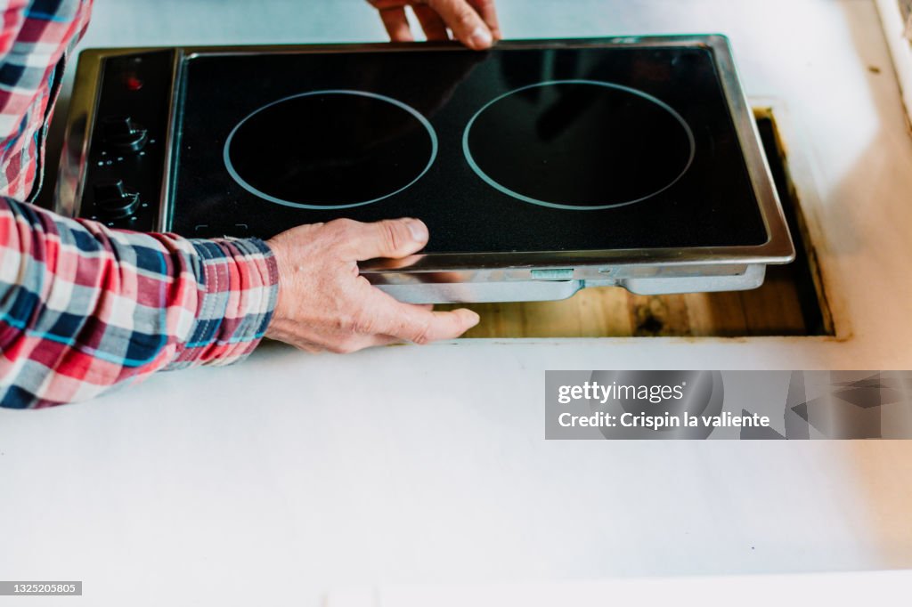 Closeup of installation of new ceramic hob in the kitchen