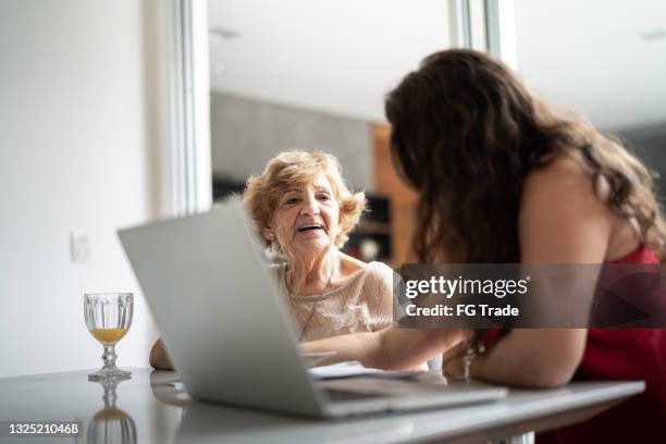 granddaughter helping granddaughter with doing home finances - grandma invoice stock pictures, royalty-free photos & images