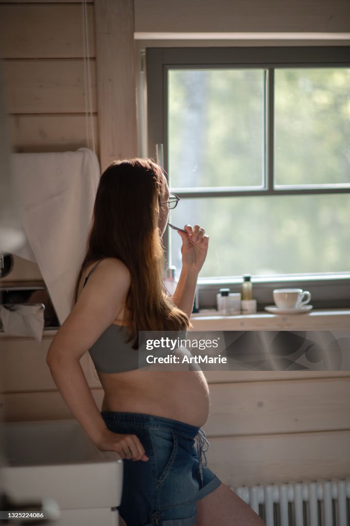 Pregnant woman in bathroom in the morning