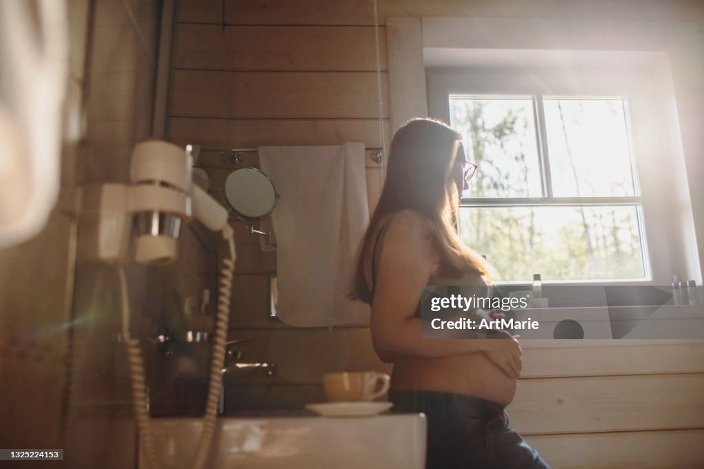 Pregnant woman in bathroom in the morning
