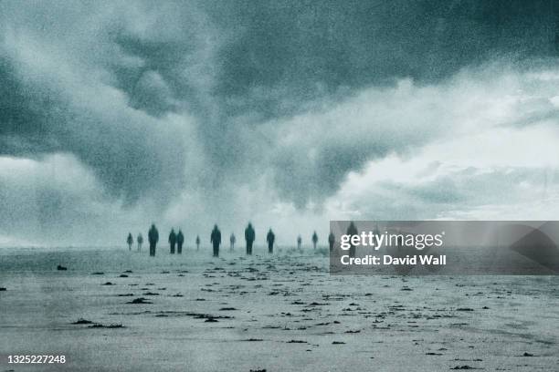 a supernatural concept. a group of blurred lost souls walking along a beach on a moody day. with an abstract, grunge edit. - espectro - fotografias e filmes do acervo