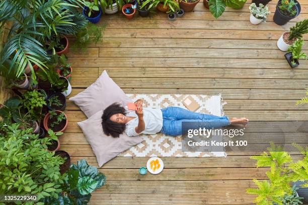 portrait of woman relaxing at home in her garden - stress free life mobile stock pictures, royalty-free photos & images