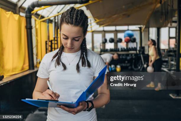 female fitness trainer writing schedule - coach clipboard stock pictures, royalty-free photos & images