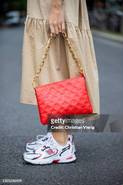 Sonia Lyson is seen wearing New Balance sneaker, beige dress Zara, red Louis Vuitton bag, Fendi sunglasses on June 24, 2021 in Berlin, Germany.