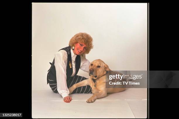 Comic actress and impressionist Faith Brown photographed with a Labrador Retriever, circa 1990.