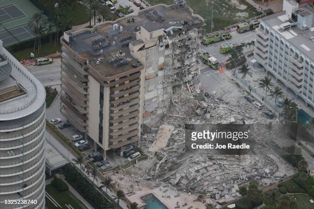 Search and rescue personnel work in the rubble of the 12-story condo tower that crumbled to the ground during a partially collapse of the building on...