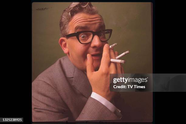 Comedian and writer Ronnie Barker smoking multiple cigarettes, circa 1968.