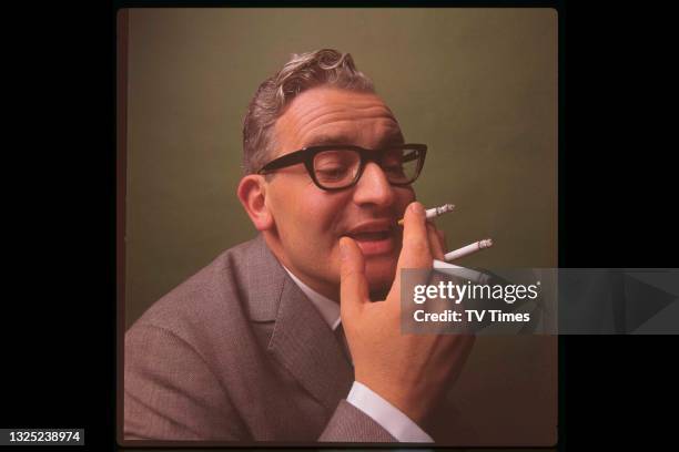 Comedian and writer Ronnie Barker smoking multiple cigarettes, circa 1968.