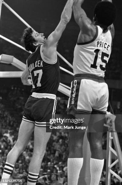 Boston Celtics forward John Havlicek contests a jump shot taken by Denver Nuggets guard Jim Price during an NBA basketball game at McNichols Arena on...