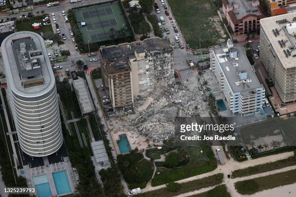 Search and rescue personnel work in the rubble of the 12-story condo tower that crumbled to the ground after a partial collapse of the building on...