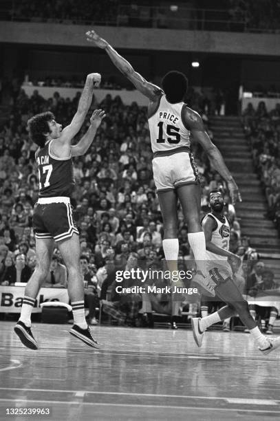 Boston Celtics guard Kevin Stacom shoots under an attempted block by Denver Nuggets guard Jim Price during an NBA basketball game at McNichols Arena...