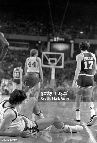 Denver Nuggets forward Bobby Jones reclines on the floor and tries to throw the ball to the referee during an NBA basketball game against the Boston...