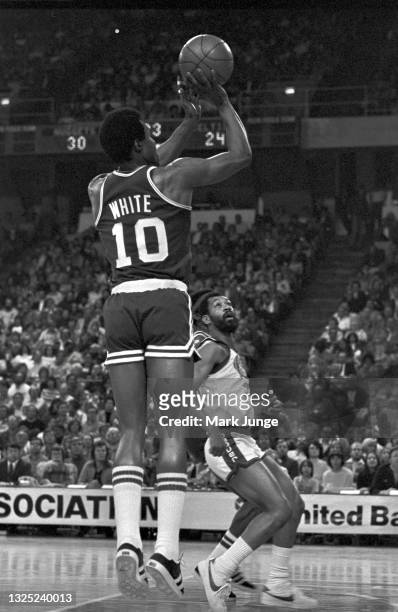 Boston Celtics guard Jo Jo White takes a jump shot over Denver Nuggets guard Roland “Fatty” Taylor during an NBA basketball game against the Boston...
