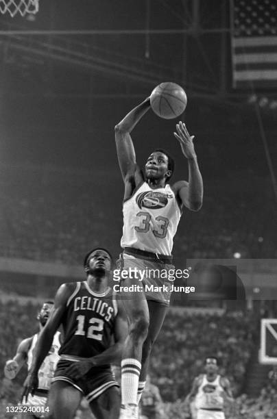 Denver Nuggets forward David Thompson goes up for a slam dunk in front of Boston Celtics forward Sidney Wicks during a game at McNichols Arena on...