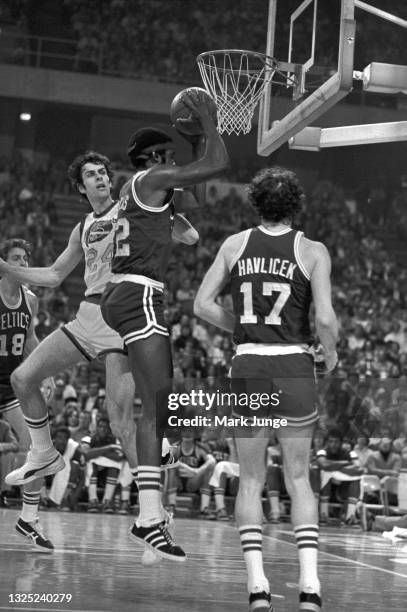 Boston Celtics forward Sidney Wicks pulls down a rebound in front of Denver Nuggets forward Bobby Jones during an NBA basketball game at McNichols...