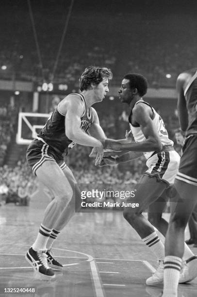 Boston Celtics center Dave Cowens checks Denver Nuggets forward David Thompson during a game at McNichols Arena on February 27, 1977 in Denver,...