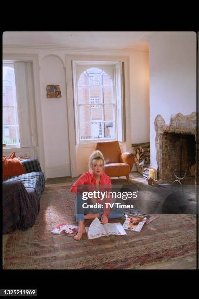 Comedian and television presenter Jenny Eclair reading magazines in her living room at home, circa 1997.