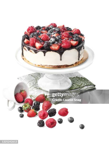 food photography of homemade  cheesecake side view covered with dark chocolate glaze, decorated with fresh garden berries on a white background isolated close up - cakestand stock-fotos und bilder