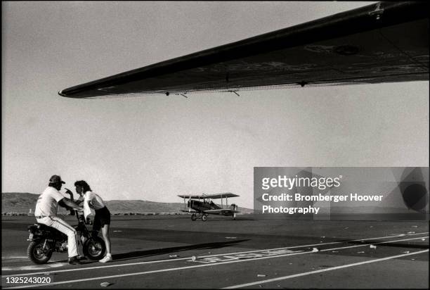 View of a man on a motorbike as a woman points a finger in his face, under the wing of a plane on the tarmac at the Reno Stead Airport during the...