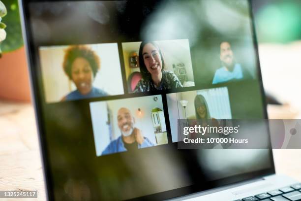 smiling faces on laptop screen during video call - community events stock-fotos und bilder