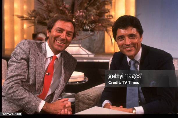 French singer Sacha Distel and host Des O'Connor on the set of light entertainment series Des O'Connor Tonight, circa November 1985.