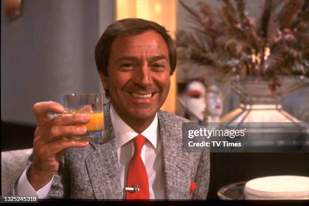Entertainer Des O'Connor raising a glass, circa 1985.