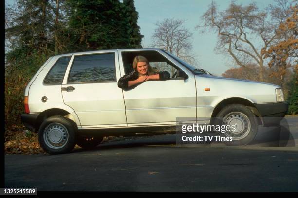 Television presenter Anneka Rice, known for her role in the game show Treasure Hunt, posed in her car, circa 1984.